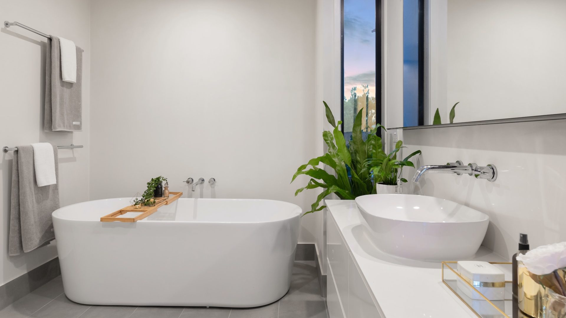 white ceramic bathtub near green potted plant