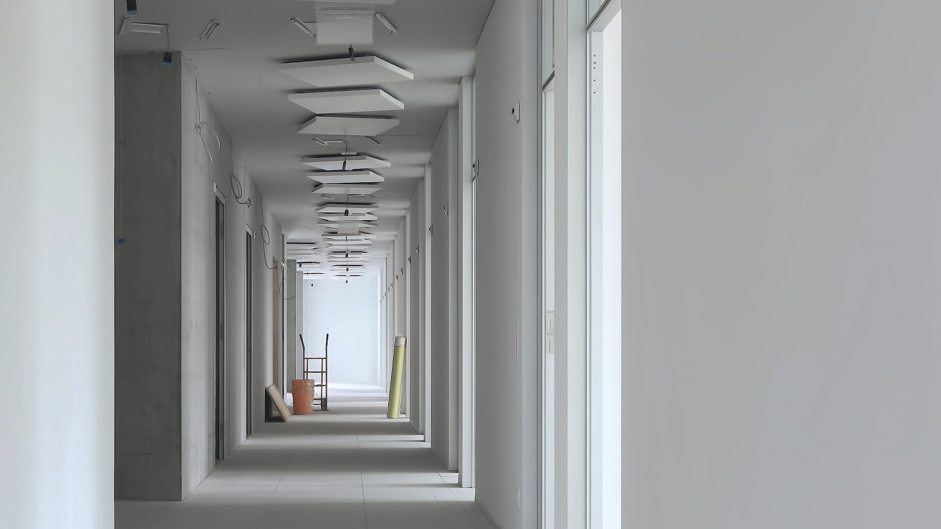 a long hallway with white walls and ceiling lights